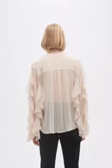 Camisa color crudo de poliéster con cuello mao y mangas largas con volados.