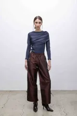 Pantalón de corte recto, de inspiración deportiva, color marrón tornasolado. Cuenta con cintura elastizada, bolsillos frontales con cierre y cordones ajustables en las pantorrillas.
