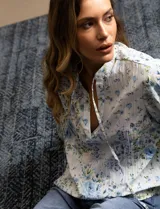 Blusa de gasa plisada estampada con flores azules, marca Floral & Ivy. Cuello a la base, escote en V y lazo de ajuste.