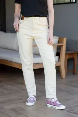 Pantalón jean negro de tiro alto, con cinco bolsillos, confeccionado en tela con elastano. Tiene cierre frontal con doble botón y cierre metálico, y detalle de cuero en la parte delantera de la pretina.