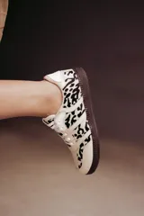 Zapatillas Adidas Samba con estampado animal print en blanco y negro, detalles en cuero beige y suela de goma color caramelo.