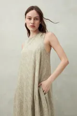 Vestido largo color beige con estampado abstracto, sin mangas y con cuello redondo.