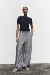 Top de punto color crema, de cuello redondo y manga corta con detalle de vivos a contraste en cuello y hombros.