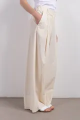 Pantalón palazzo color crema de lino con pinzas, de calce relajado y tiro alto.