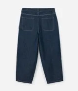 Pantalón de jeans azul oscuro, corte amplio tipo skater, con cintura con trabillas, cierre tradicional, bolsillos y costuras contrastantes.