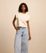 Pantalón wide leg de jeans marmorizado celeste, con bolsillos delanteros y traseros, cintura con trabillas, cierre con botón y cremallera, y abertura lateral en el bajo.