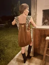 Minivestido negro de terciopelo con detalles brillantes y apliques de tela bordada en los hombros.