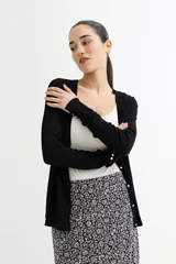 Cárdigan negro de tejido de punto fino con escote en V, cierre frontal con botones dorados y mangas largas con puños ajustados.