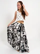 Falda larga de algodón con estampado floral en tonos marrón y blanco. Tiene elástico en la cintura y viene con un cinto de rafia elastizado desmontable.