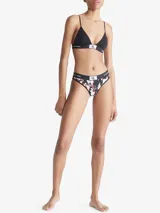 Bombacha bikini de algodón con estampado floral en tonos blanco y rojo sobre fondo negro. Cintura elástica con logo de Calvin Klein.