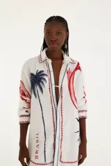 Camisa blanca con estampado de palmeras, peces y la palabra "Brasil" en rojo y azul.