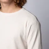 Buzo de hombre color crudo, de corte largo y tejido waffle.