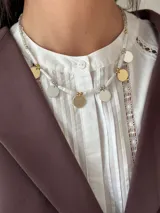 Collar corto con perlas de río naturales, cuentas metálicas de acero quirúrgico, medallitas bañadas en plata y oro y mostacillas. Se cierra con cadena de acero quirúrgico y ganchito para regular el largo.