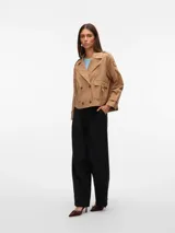 Trench corto color beige con cierre cruzado y bolsillos frontales.