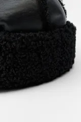 Gorro negro combinado en tejido efecto piel y efecto borreguillo.