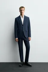 Blazer slim fit azul marino confeccionado en tejido con viscosa. Cuello con solapas de muesca, manga larga con puño abotonado, bolsillo de vivo en pecho y de solapa en cadera, bolsillo interior, bajo con aberturas en espalda y cierre frontal con botones.