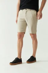 Bermuda de lino y algodón color beige, con bolsillos laterales y traseros, cierre con botón y presillas para cinturón.