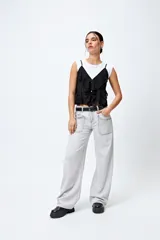 Pantalón de jean gris oscuro, tiro bajo, corte baggy y doble bolsillo.