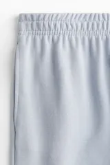Pantalón de felpa celeste, de corte relajado con cintura elástica fruncida, bolsillos laterales discretos y piernas rectas.