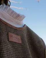 Chaleco marrón con diseño a cuadros y borde de cuero.