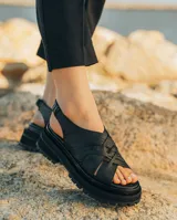 Sandalias de cuero vacuno color marrón, con tiras anchas cruzadas en el empeine, elástico en el talón y doble suela de goma deportiva.