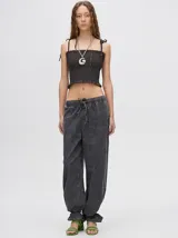 Top corto negro con textura fruncida, tirantes finos con lazos ajustables y corte crop.