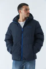 Campera puffer azul marino para hombre, con capucha ajustable, cuello alto, bolsillos con cierre y logo en goma.