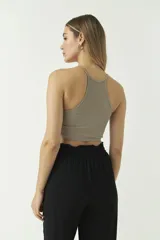 Top corto color beige, sin mangas y de escote redondo.