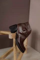 Botas cortas de cuero negro con textura tipo cocodrilo, caña alta, cierre con hebilla y taco de madera.