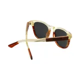 Lentes de sol con montura bicolor, parte superior color crema y parte inferior con estampado carey. Patillas negras con logo Indie grabado.
