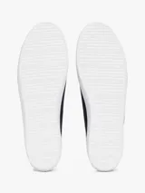 Zapatillas Tommy Hilfiger de lona azul marino con suela blanca de goma y talón dorado metalizado.