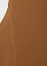 Vestido largo de tejido de punto fino color camel, sin mangas y con cuello redondo. Presenta un corte evasé que se ajusta al cuerpo en la parte superior y cae con vuelo en la falda.