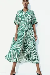 Vestido midi camisero con estampado de rayas verdes y blancas, cuello camisero, botonadura frontal, mangas cortas raglán, elástico en la cintura y cinturón extraíble para atar.
