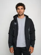 Campera corta de abrigo Umbro Crafted Pro, color negro con paneles laterales en gris. Presenta capucha con cordón ajustable, cierre frontal completo y logo de la marca bordado en el pecho.
