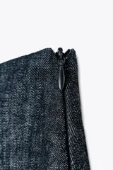Minifalda pantalón de tiro alto confeccionada en denim azul oscuro. Presenta una abertura delantera y cierre lateral con cremallera oculta.