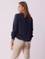 Blusa azul marino de gasa con escote en V y mangas largas con puño.