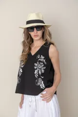 Blusa sin mangas de algodón color blanco con bordados florales negros en el frente y escote en V.