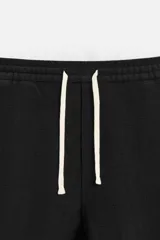 Pantalón negro de corte recto con cintura elástica ajustable con cordón, bolsillos laterales y traseros.