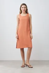 Vestido midi de lino color durazno, corte recto y sin mangas.