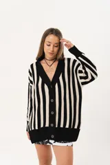 Saco oversize tejido a rayas verticales en blanco y negro, con escote en V y botones.