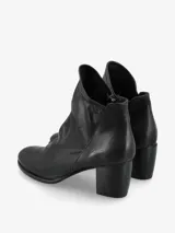 Botín de cuero negro con diseño moderno y silueta estilizada. Su taco ancho brinda estabilidad y comodidad, mientras que el corte limpio realza la elegancia del modelo.