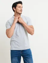 Chomba celeste con estampado de lunares blancos, cuello clásico y mangas cortas.