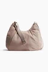 Bolso de deporte color rosa con correa ancha ajustable y cierre.