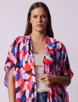 Kimono tejido con estampado floral multicolor y terminación de ruedo con borlas negras.