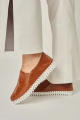 Zapatilla slipper color marrón confeccionada en cuero vacuno, sin forro y con suela de goma flexible.