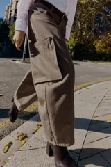 Pantalón cargo de tiro alto color marrón topo, con pierna ancha y holgada que se estrecha hacia el tobillo. Presenta bolsillos delanteros, bolsillo de plastrón lateral y falso bolsillo de vivo en la espalda.