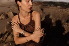 Blusa marrón de lino con elástico en la cintura y tiras trenzadas regulables que se cruzan en la espalda.