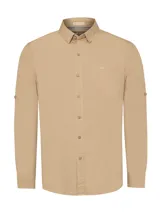 Camisa de manga larga color beige, confeccionada en algodón orgánico. Cuenta con cuello camisero, cierre con botones de madera, un bolsillo en el pecho y tecnología UPF 20+ para protección UV.