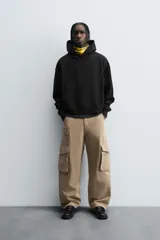 Pantalón cargo color beige, de corte relaxed fit, con bolsillos frontales, traseros con solapa y bolsillos laterales tipo parche con solapa.