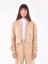 Campera corta color beige con cierre frontal, capucha y puños ajustados.